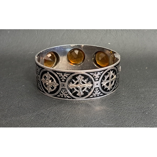 81 - UNUSUAL CAIRNGORM AND BLACK ENAMEL DECORATED SILVER BANGLE
the three round cut cairngorms, each meas... 