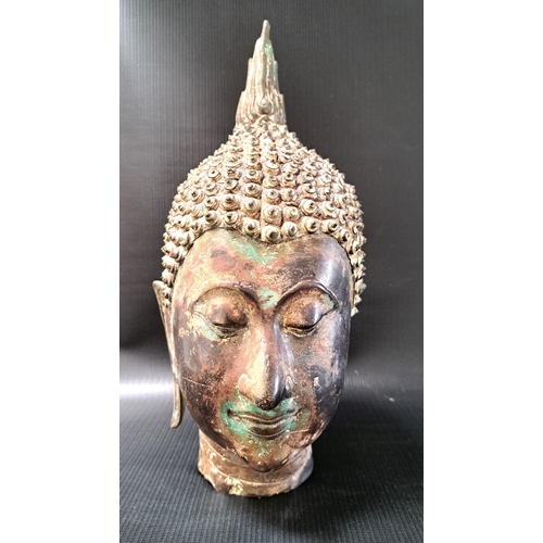 264 - BURMESE BRONZE BUDDHA HEAD
with closed eyes, elongated earlobes and curled headdress, 31cm high