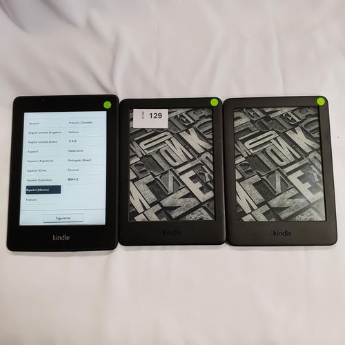 129 - THREE AMAZON KINDLE E-READERS 
comprising 2x Basic 3, serial numbers G091 0L04 9224 00HE and G090 VB... 