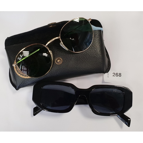 268 - TWO PAIRS OF DESIGNER SUNGLASSES
comprising Prada (very worn) and Ray-Ban (in case)