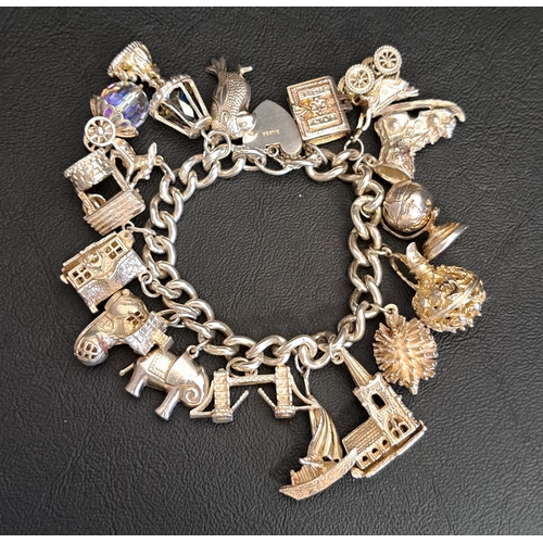 15 - HEAVY SILVER CHARM BRACELET
with a good selection of charms including articulated examples, includin... 