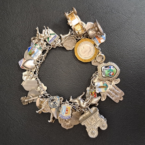 103 - SILVER CHARM BRACELET
with a large number of souvenir and other charms, total weight approximately 1... 