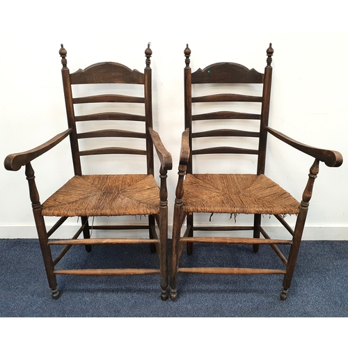 431 - PAIR OF RUSTIC EARLY 19th CENTURY ASH AND ELM LADDERBACK ARMCHAIRS
with spindle finials and rush sea... 