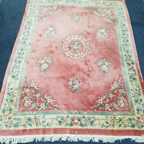 498 - LARGE CHINESE WOOLLEN CARPET 
with floral motifs on pink and cream ground, with cream fringing, 367 ... 