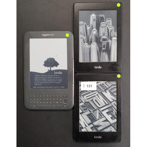 131 - THREE AMAZON KINDLE E-READERS
comprising a Paperwhite 2, serial number 90D4 2201 3527 03CK; a Paperw... 