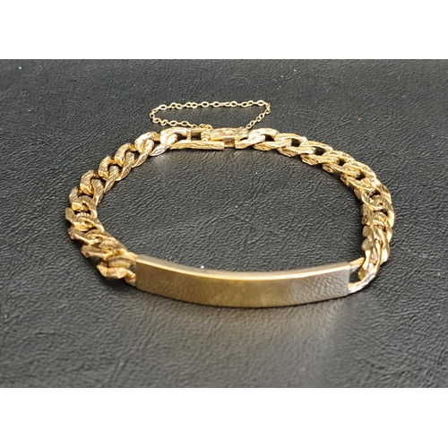 39 - NINE CARAT GOLD IDENTITY BRACELET
the blank panel flanked by textured curb links, with safety chain,... 