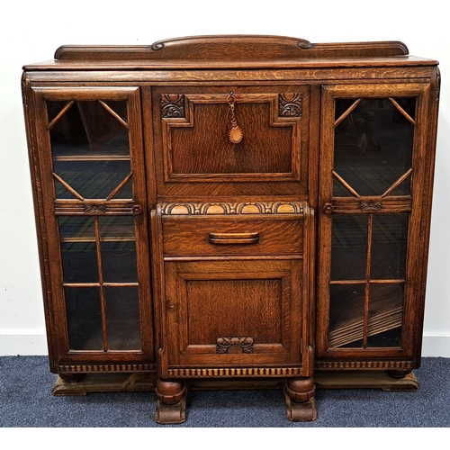 590 - AN 1930s OAK SIDE BY SIDE GLAZED FRONTED BUREAU BOOK CASE
with fold down centre to reveal pigeon hol... 