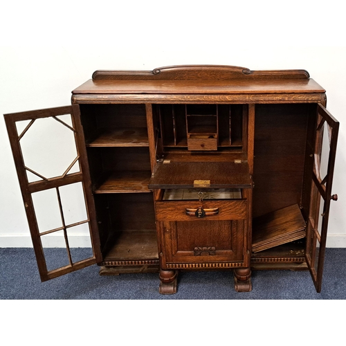 590 - AN 1930s OAK SIDE BY SIDE GLAZED FRONTED BUREAU BOOK CASE
with fold down centre to reveal pigeon hol... 