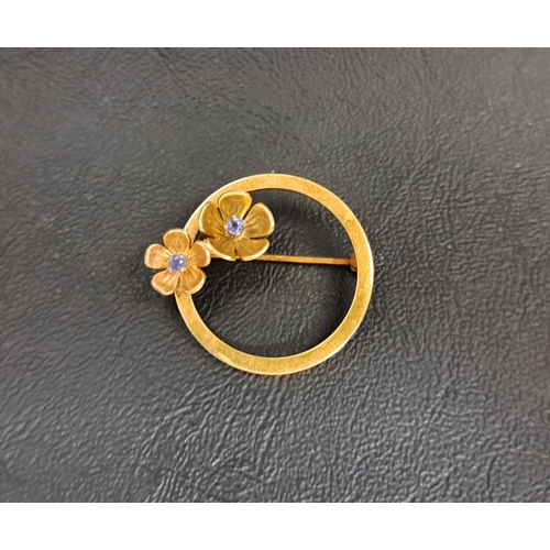 26 - BLUE TOPAZ SET FOURTEEN CARAT GOLD BROOCH
the circular brooch set with two gem set flower heads, tot... 