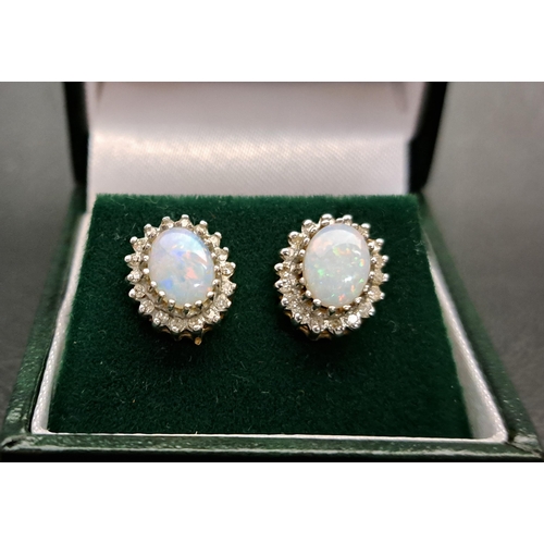 48 - PAIR OF OPAL AND DIAMOND CLUSTER EARRINGS
each of the oval cabochon opals measuring approximately 8m... 