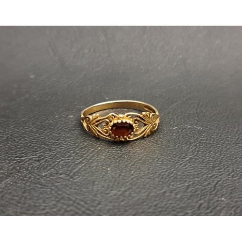 83 - PRETTY GARNET SINGLE STONE RING
the oval cut garnet approximately 0.4cts in pierced scroll decorated... 