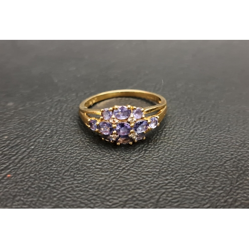 94 - TANZANITE CLUSTER RING
on nine carat gold shank with decorative split shoulders, ring size P-Q