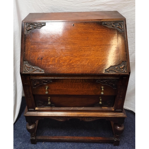 565 - OAK BUREAU
the fall flap opening to reveal fitted interior, above two drawers with drop handles, rai... 