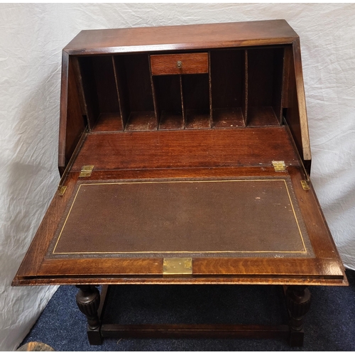 565 - OAK BUREAU
the fall flap opening to reveal fitted interior, above two drawers with drop handles, rai... 