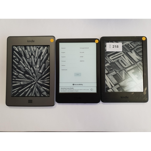 218 - THREE AMAZON KINDLE E-READERS
comprising a Basic 4, serial number G092 AP03 3072 02UH; a Basic 3, se... 