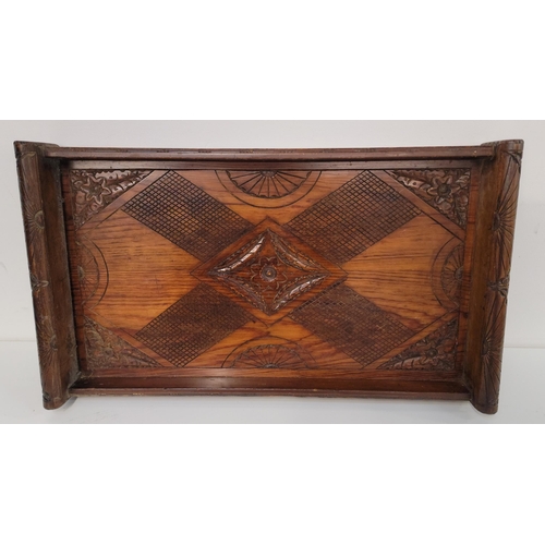 LARGE CARVED TRAY
in tropical hardwood with foliate, shell and geometric design, 69 x 40 x 9