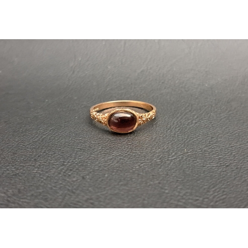 39 - CABOCHON GARNET SINGLE STONE RING
on nine carat rose gold shank with decorative scroll decorated sho... 