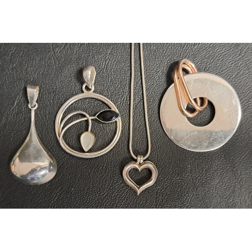 40 - FOUR SILVER PENDANTS
comprising a teardrop design pendant, another set with mother of pearl and blac... 