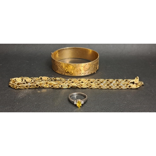 115 - NINE CARAT GOLLED GOLD BANGLE
with engraved floral decoration and a safety chain; together with an e... 