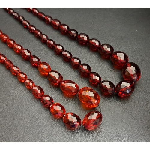 56 - TWO FACETED AMBER COLOURED BEAD NECKLACES
the largest bead on each approximately 26mm long, one neck... 