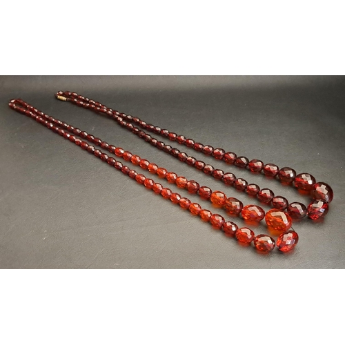 56 - TWO FACETED AMBER COLOURED BEAD NECKLACES
the largest bead on each approximately 26mm long, one neck... 