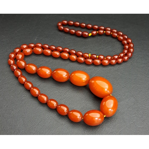 129 - GRADUATED ORANGE/BROWN AMBER COLOURED BEAD NECKLACE
the largest bead approximately 29.2mm long, the ... 