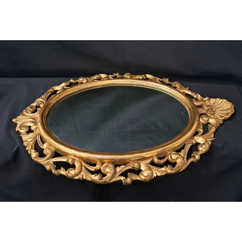 479 - LARGE ORNATE GILT EDGED WALL MIRROR
with Oyster shell detail to the top and edged in swags, 92 x 58c... 