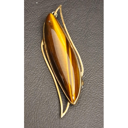 22 - TIGER'S EYE BROOCH/PENDANT
in nine carat gold, 6.5cm long