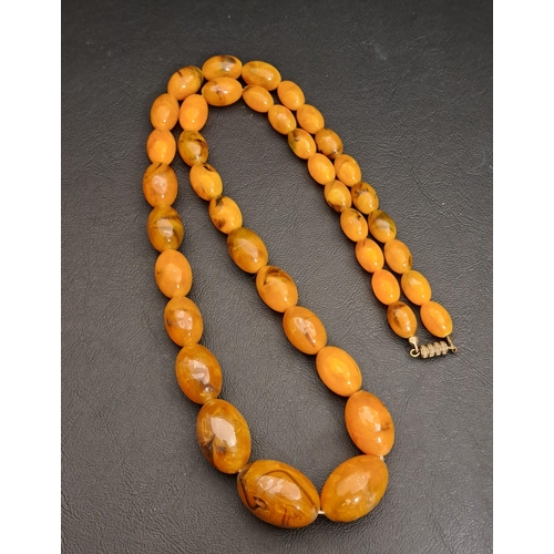 28 - GRADUATED AMBER COLOURED BEAD NECKLACE
the largest bead 29.2mm long, the necklace 76cm long and appr... 