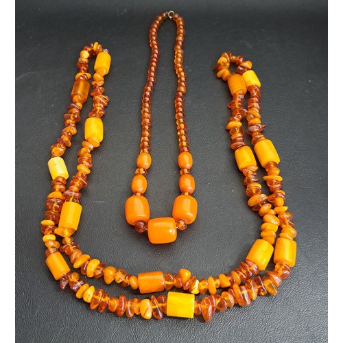 164 - TWO AMBER BEAD NECKLACES
the longer example interspersed with cylindrical butterscotch amber beads, ... 