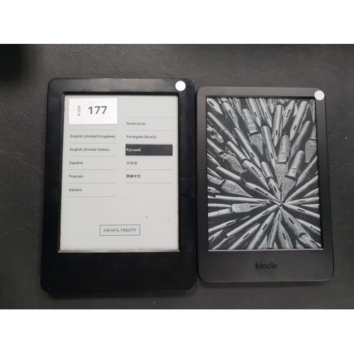 177 - TWO AMAZON KINDLE E-READERS
comprising a Basic 4, serial number G093 KM06 5106 0AX1; and a Basic, se... 