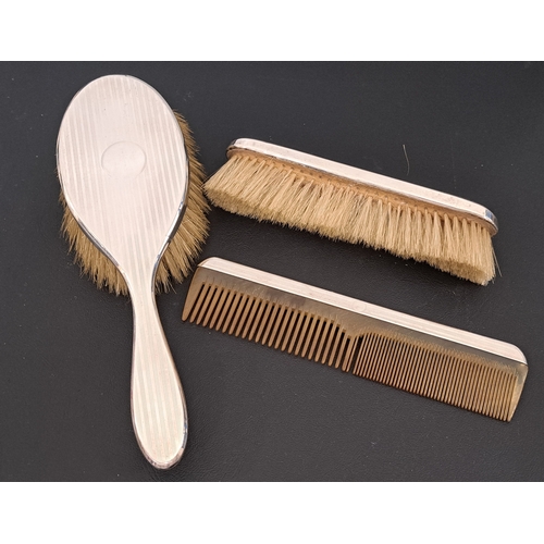 167 - GEORGE V SILVER BACKED DRESSING TABLE SET
comprising a hairbrush, a clothes brush and a comb, all wi... 