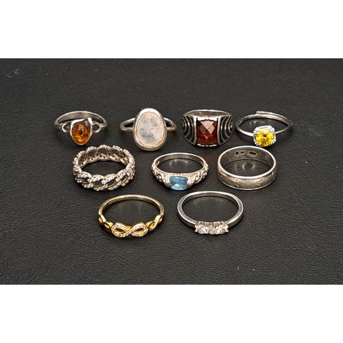 36 - NINE SILVER RINGS
of various sizes and designs, including examples set with blue topaz, rainbow moon... 