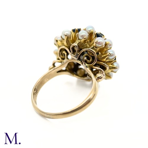 67 - A Pearl and Sapphire Cluster Ring 

The modernist 14ct yellow gold ring is set with pearls and sapph... 