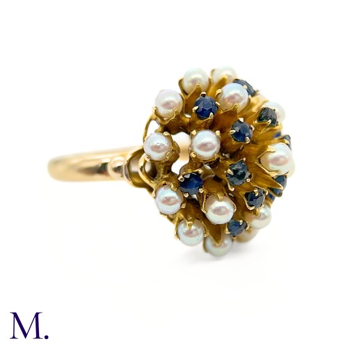 67 - A Pearl and Sapphire Cluster Ring 

The modernist 14ct yellow gold ring is set with pearls and sapph... 