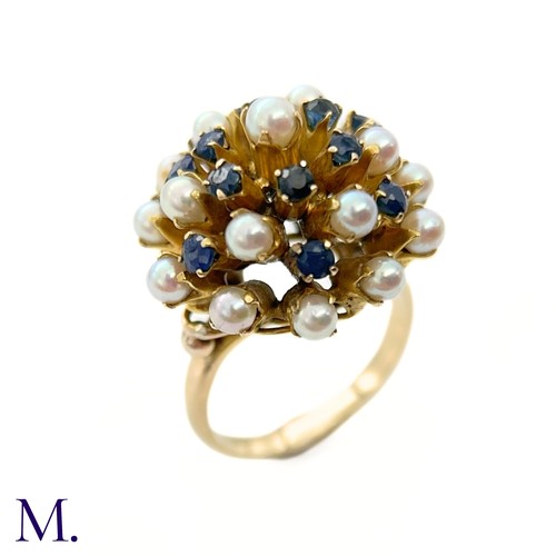 67 - A Pearl and Sapphire Cluster Ring 

The modernist 14ct yellow gold ring is set with pearls and sapph... 