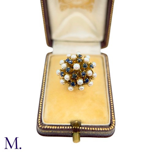 67 - A Pearl and Sapphire Cluster Ring 

The modernist 14ct yellow gold ring is set with pearls and sapph... 