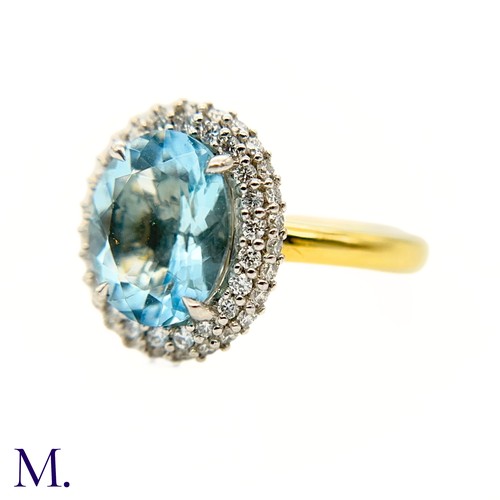 26 - An Aquamarine and Diamond Halo Ring

The 18ct yellow gold ring is set with a good colour oval-cut aq... 