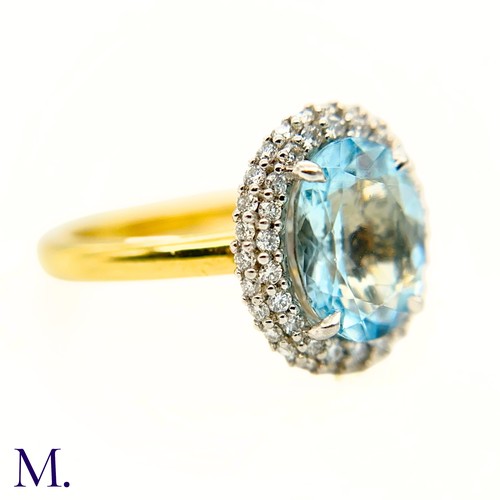 26 - An Aquamarine and Diamond Halo Ring

The 18ct yellow gold ring is set with a good colour oval-cut aq... 