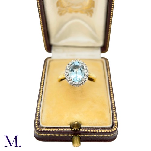 26 - An Aquamarine and Diamond Halo Ring

The 18ct yellow gold ring is set with a good colour oval-cut aq... 