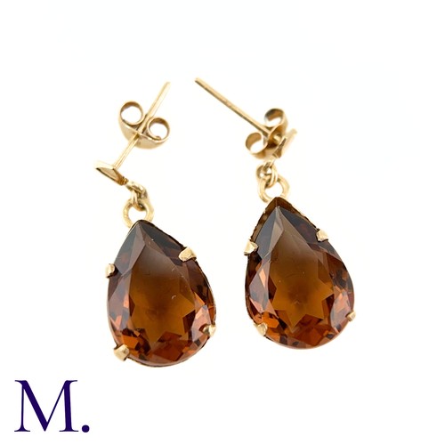 22 - A Pair of Gemstone Earrings

The 9ct yellow gold earrings are set with a burnt orange-brown pear-sha... 