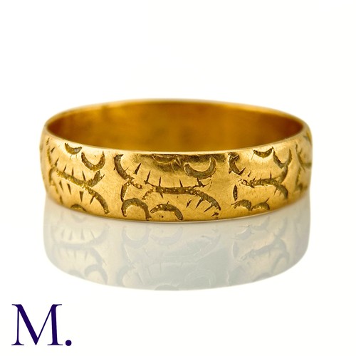 35 - A Carved 18ct Gold Band

The 18ct yellow gold band is engraved with recurrent patterns.

Weight: 4.3... 