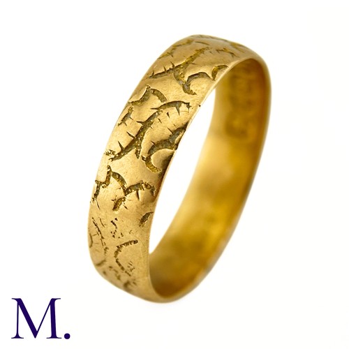 35 - A Carved 18ct Gold Band

The 18ct yellow gold band is engraved with recurrent patterns.

Weight: 4.3... 