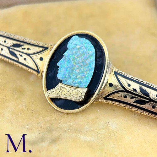 72 - A Carved Opal and Enamel Brooch

The unusual antique gold brooch is set with an impressive carved op... 