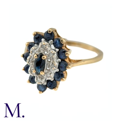 9 - A Sapphire and Diamond Ring in 9k yellow gold, the central marquise cut sapphire surrounded by a bor... 