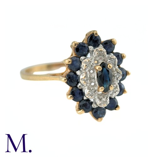 9 - A Sapphire and Diamond Ring in 9k yellow gold, the central marquise cut sapphire surrounded by a bor... 