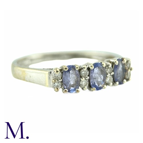 8 - A Tanzanite And Diamond Ring, in 9k white gold, the three oval cut tanzanites punctuated by pairs of... 