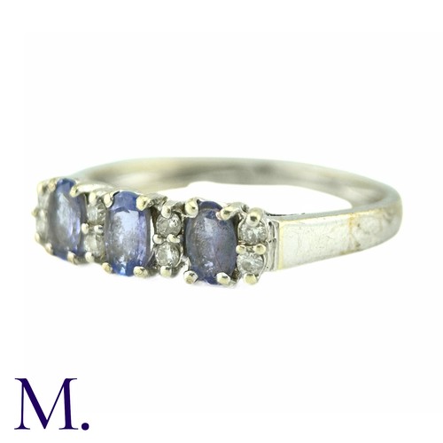 8 - A Tanzanite And Diamond Ring, in 9k white gold, the three oval cut tanzanites punctuated by pairs of... 