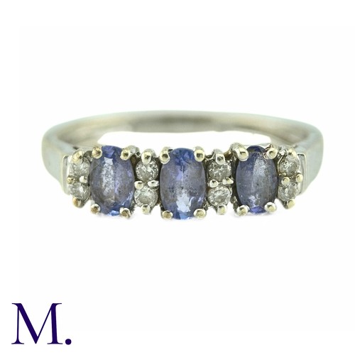 8 - A Tanzanite And Diamond Ring, in 9k white gold, the three oval cut tanzanites punctuated by pairs of... 