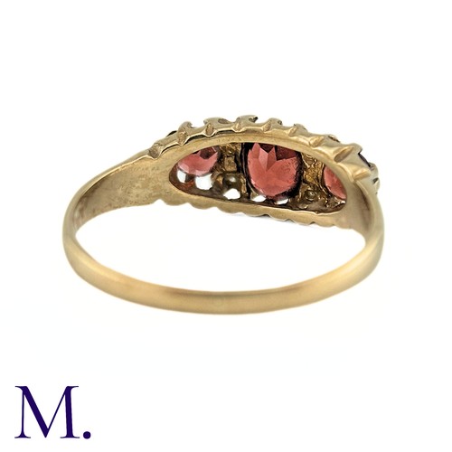 7 - A Garnet and Diamond Ring, in 9k yellow gold, the three oval cut Garnets punctuated by pairs of roun... 